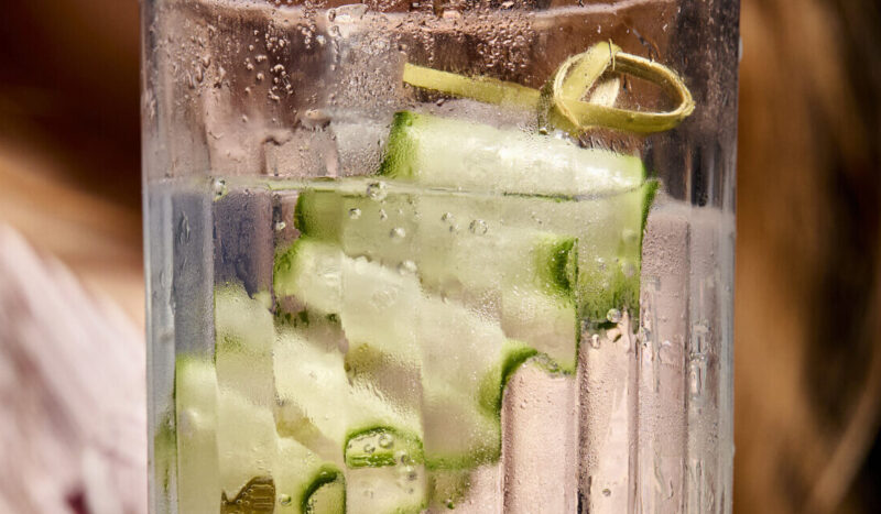 Person holding a drink and laughing